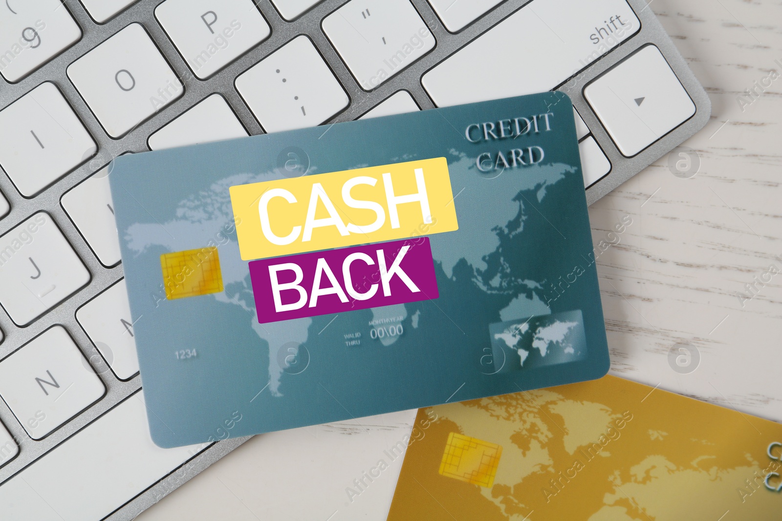 Image of Cashback credit cards and keyboard on white wooden table, flat lay