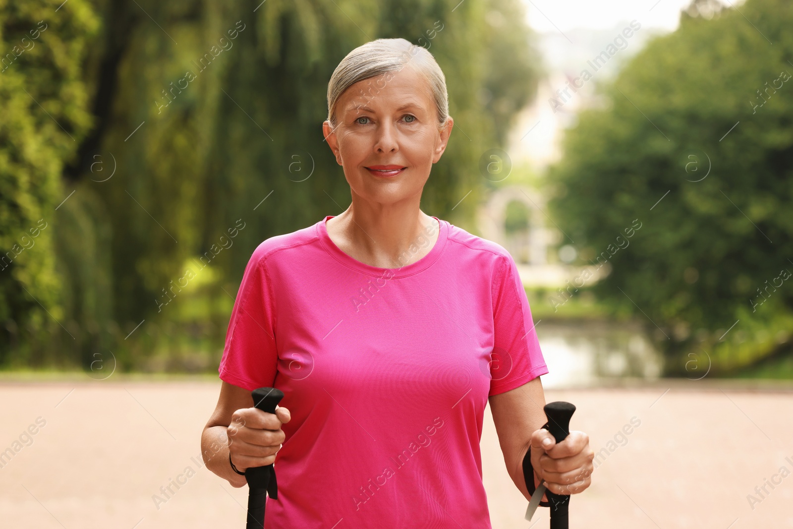 Photo of Senior woman with Nordic walking poles outdoors