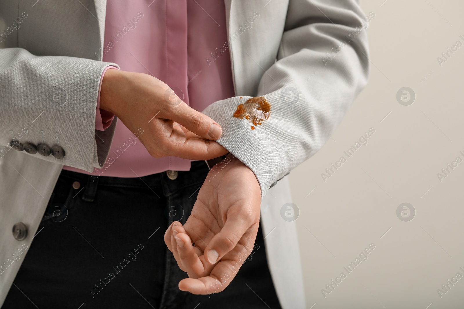 Photo of Woman showing stain of coffee on her jacket against white background, closeup. Space for text