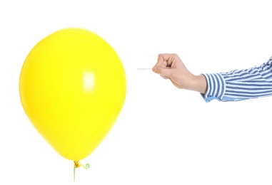 Photo of Woman piercing yellow balloon on white background, closeup