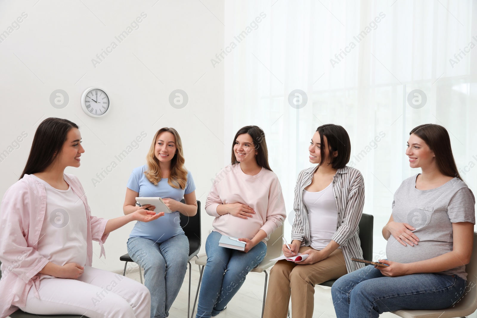 Photo of Group of pregnant women at courses for expectant mothers indoors