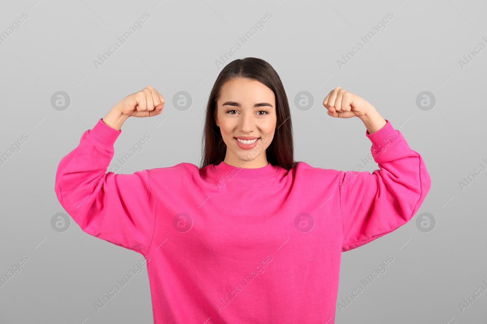 Photo of Strong woman as symbol of girl power on light grey background. 8 March concept