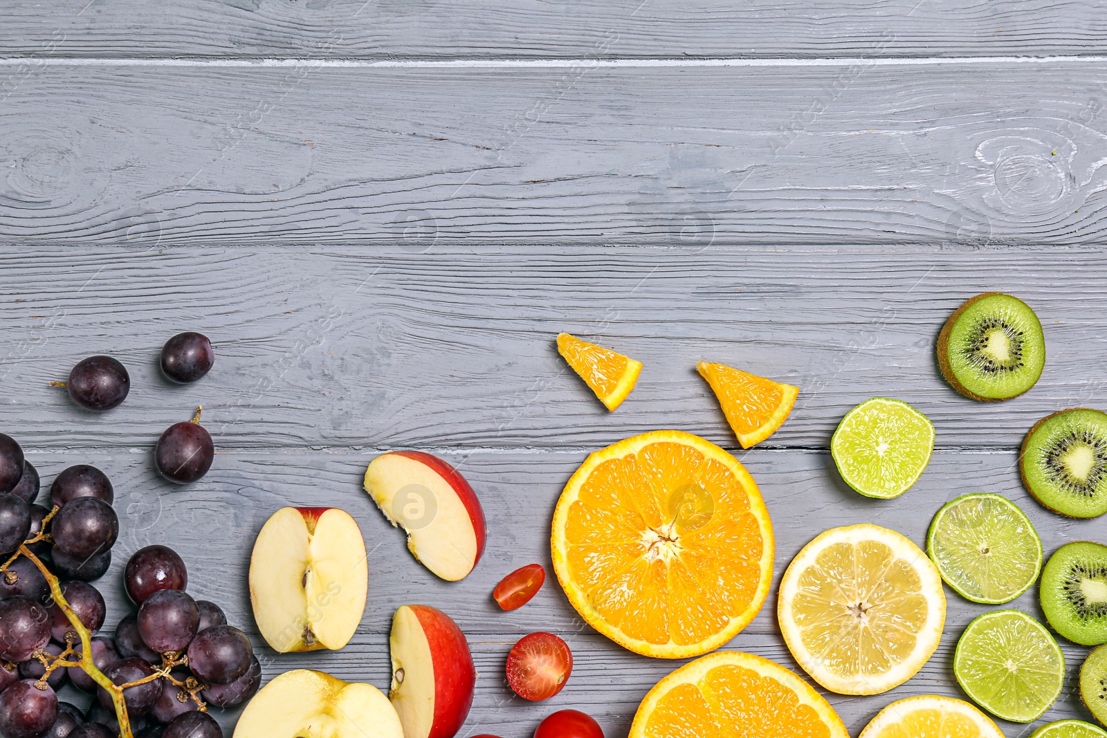 Photo of Rainbow composition with fresh fruits on wooden background, flat lay