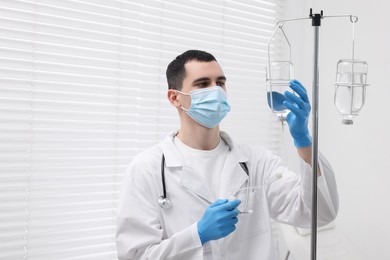 Photo of Doctor setting up IV drip in hospital, space for text