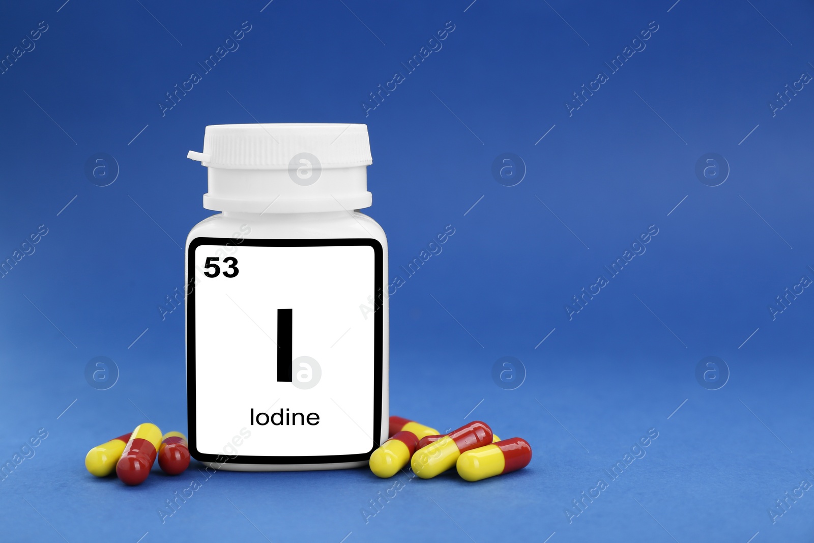 Photo of Plastic jar and iodine pills on blue background. Space for text