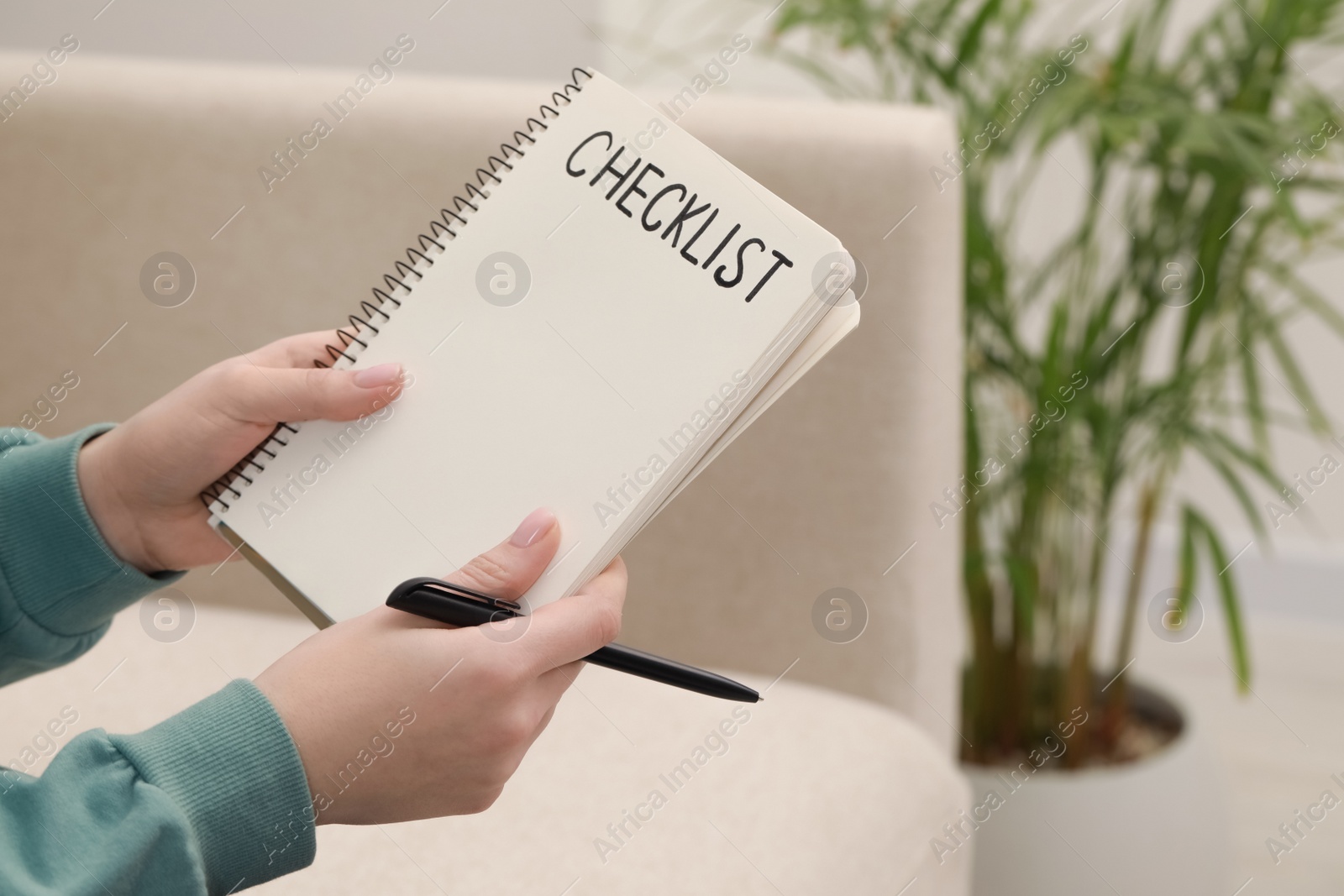 Photo of Woman holding notebook with inscription Checklist and pen indoors, closeup. Space for text