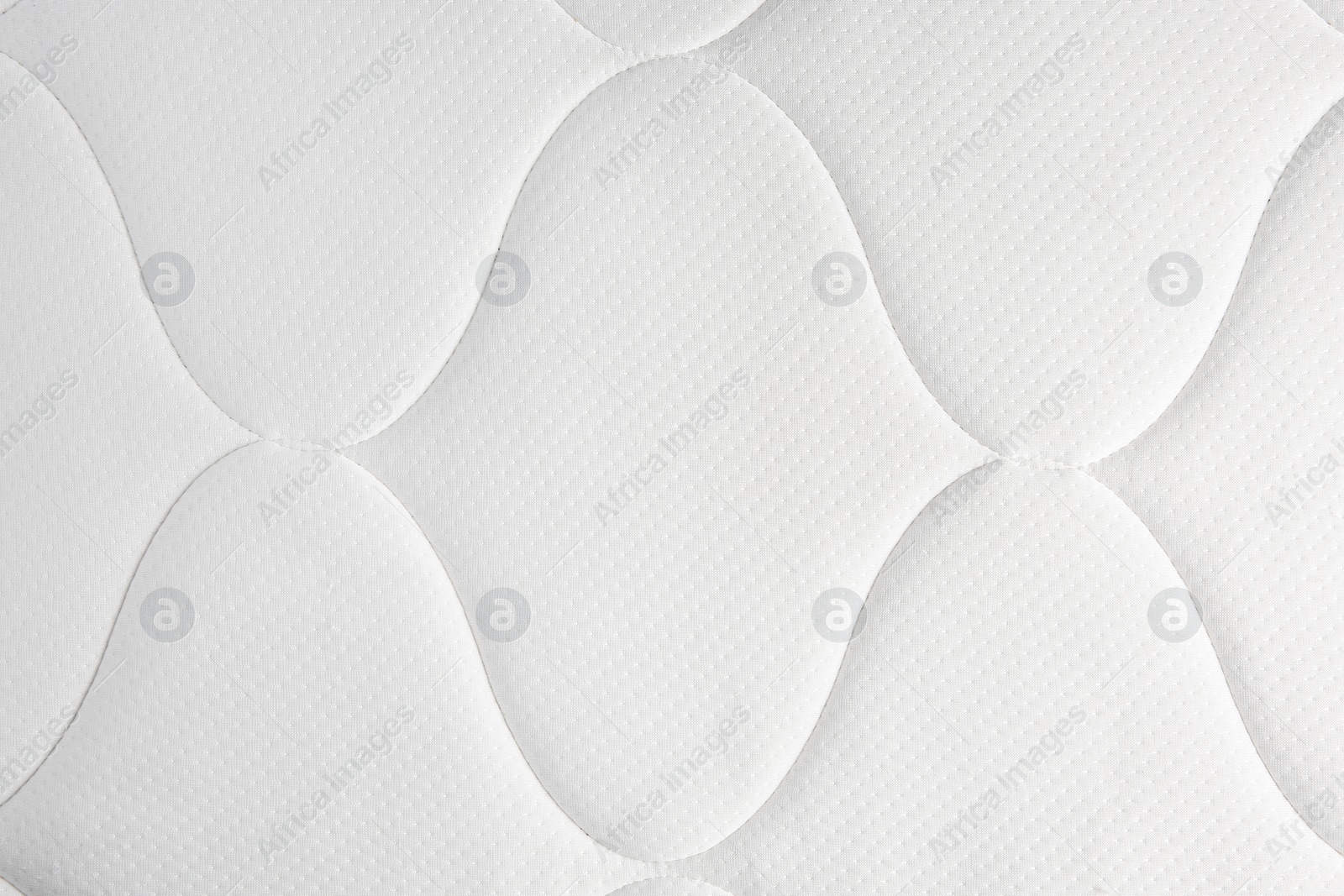 Photo of Clean white mattress as background, top view. After use of fabric shaver