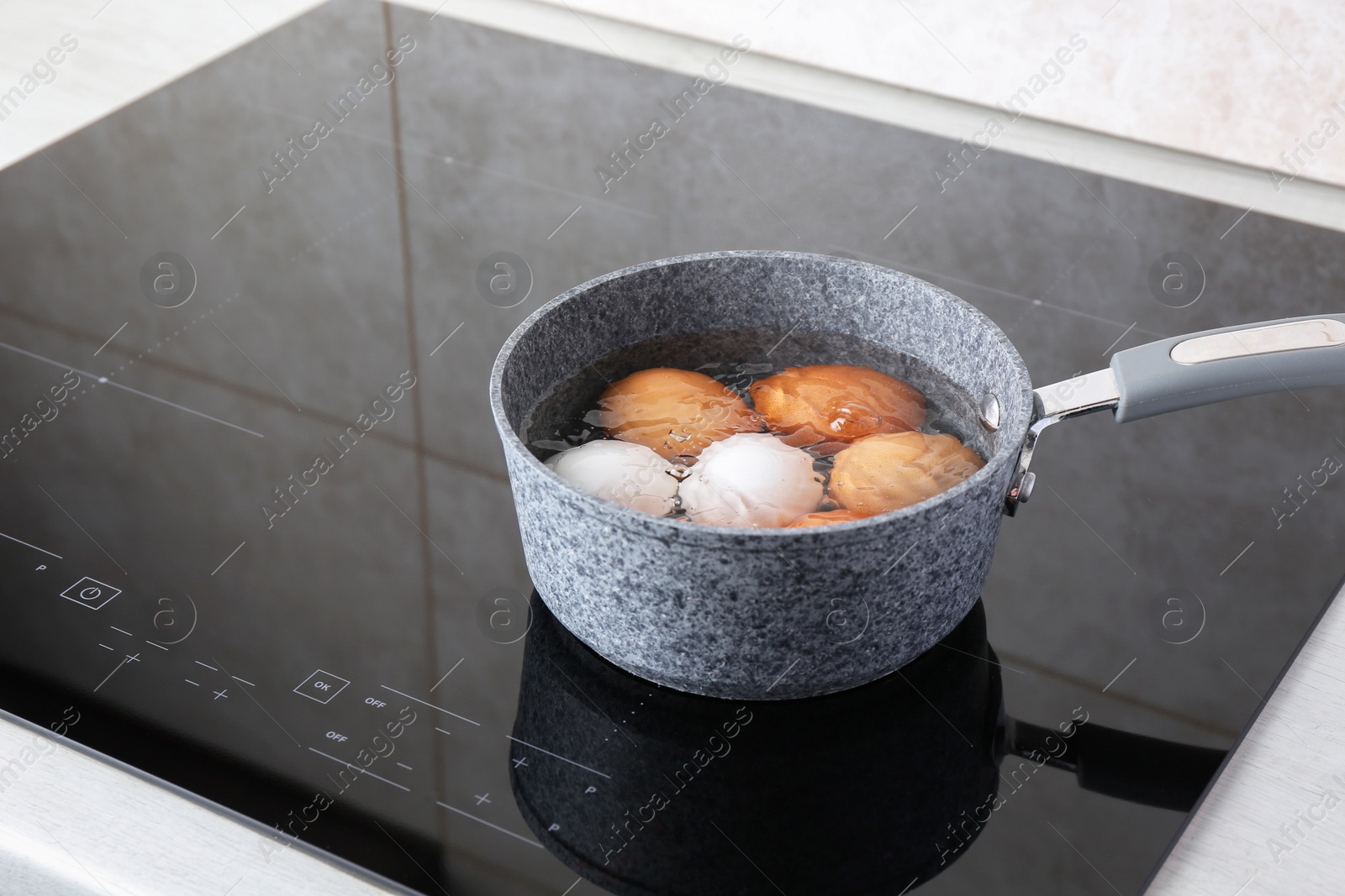 Photo of Chicken eggs boiling in saucepan on electric stove. Space for text