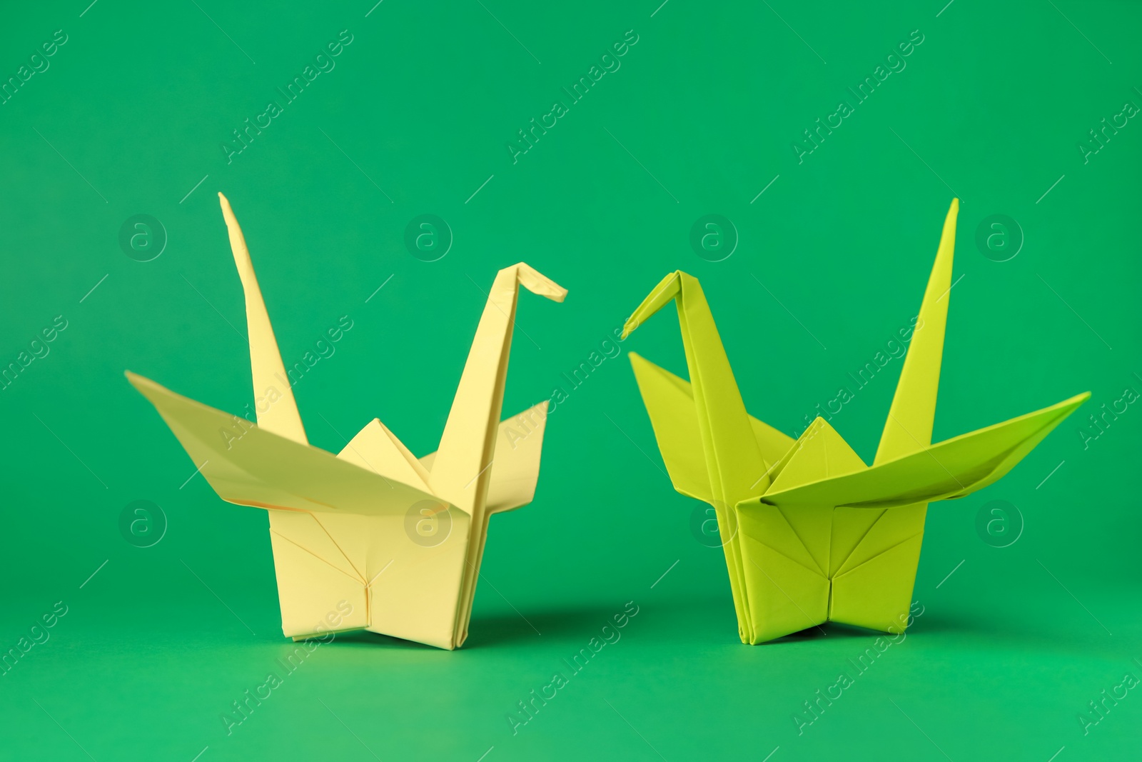 Photo of Colorful paper origami cranes on green background