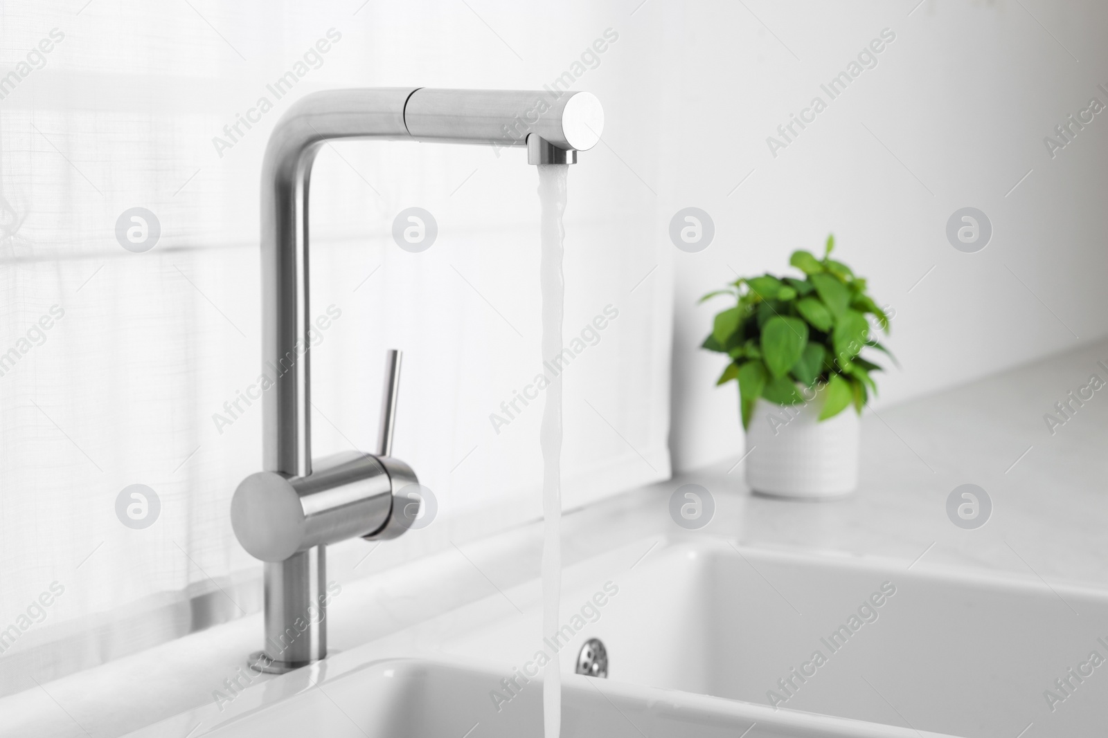 Photo of Stream of water flowing from tap in kitchen