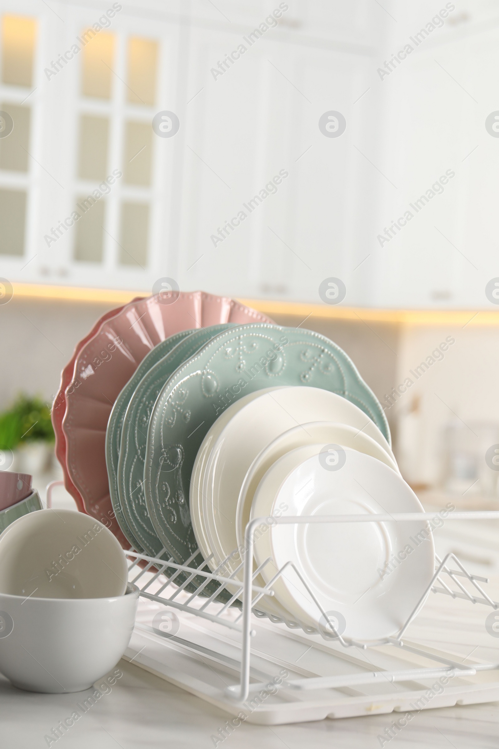 Photo of Many different clean dishware on white table in kitchen