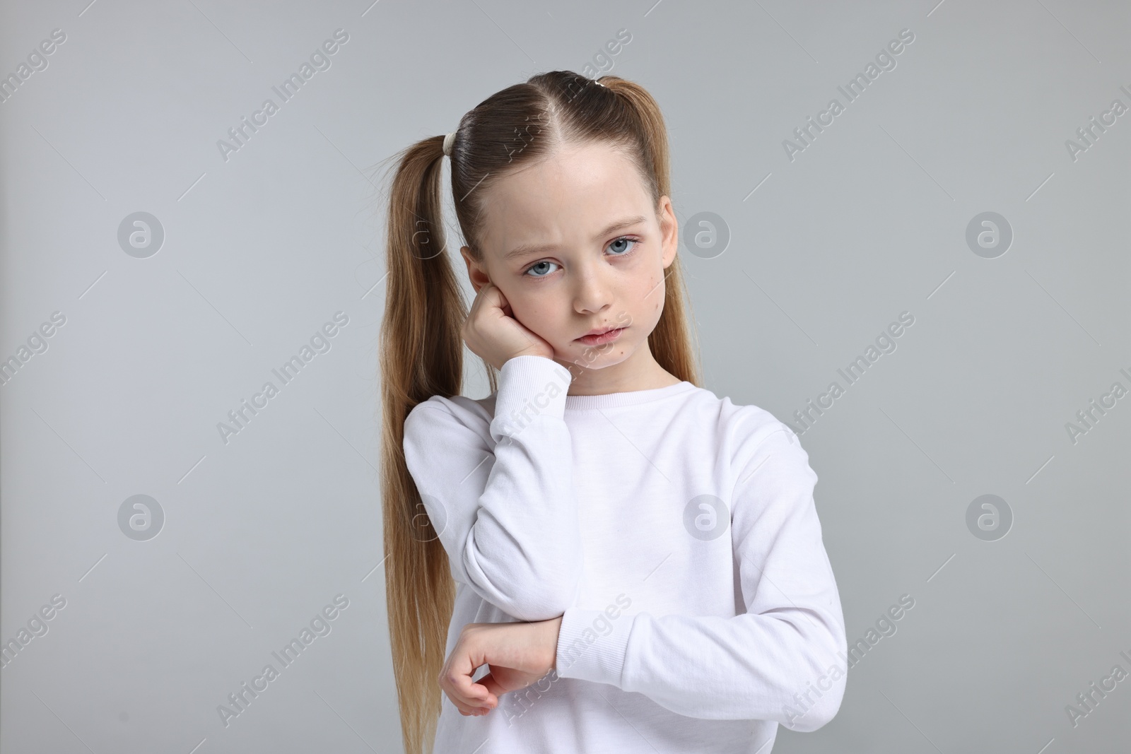 Photo of Portrait of sad girl on light grey background