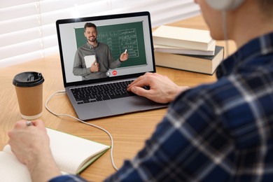 Image of E-learning. Young man having online lesson with teacher via laptop at home, closeup