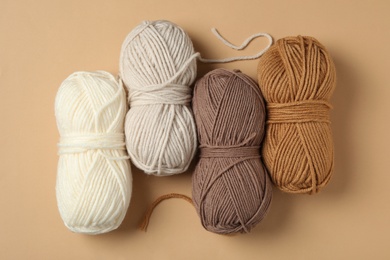 Photo of Soft woolen yarns on beige background, flat lay