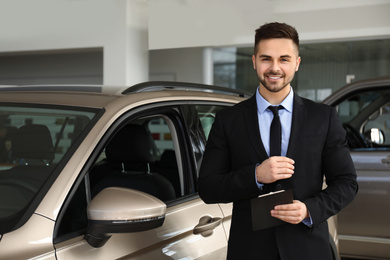 Photo of Salesman with clipboard near car in dealership