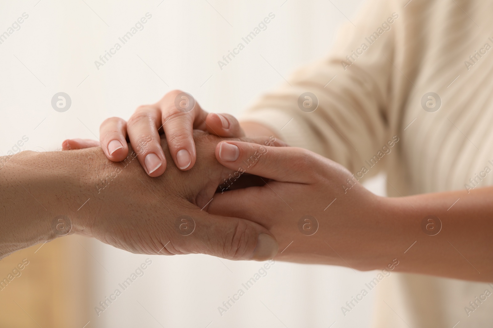 Photo of Trust and deal. Man with woman joining hands on blurred background, closeup