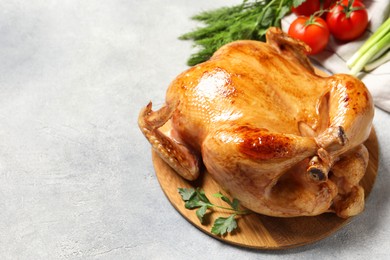 Photo of Tasty roasted chicken with parsley on light grey table, space for text