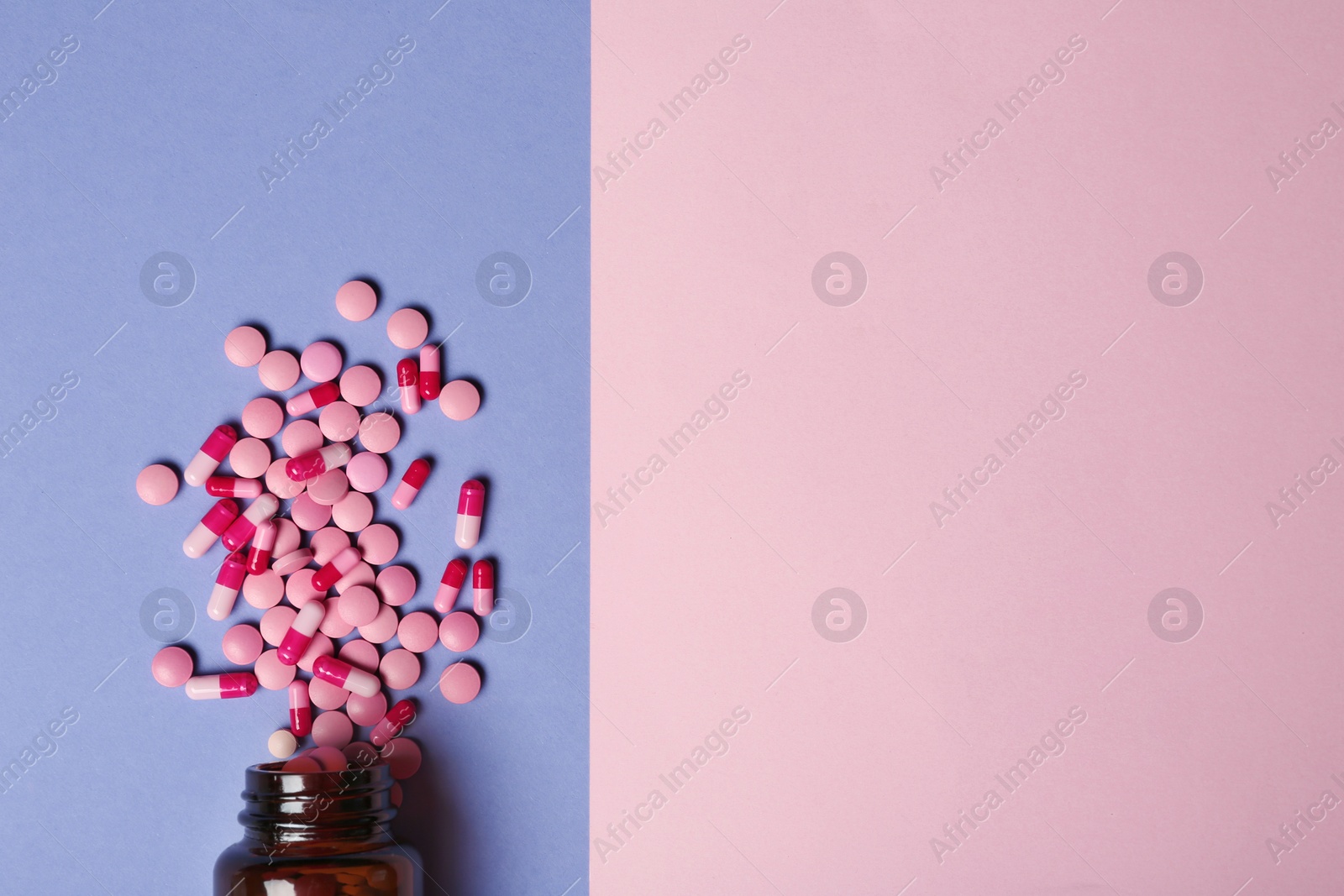 Photo of Bottle with vitamin pills and capsules on color background, flat lay. Space for text