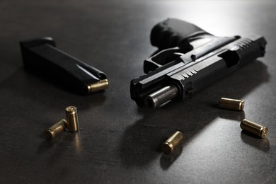 Photo of Handgun, magazine and bullets on grey table