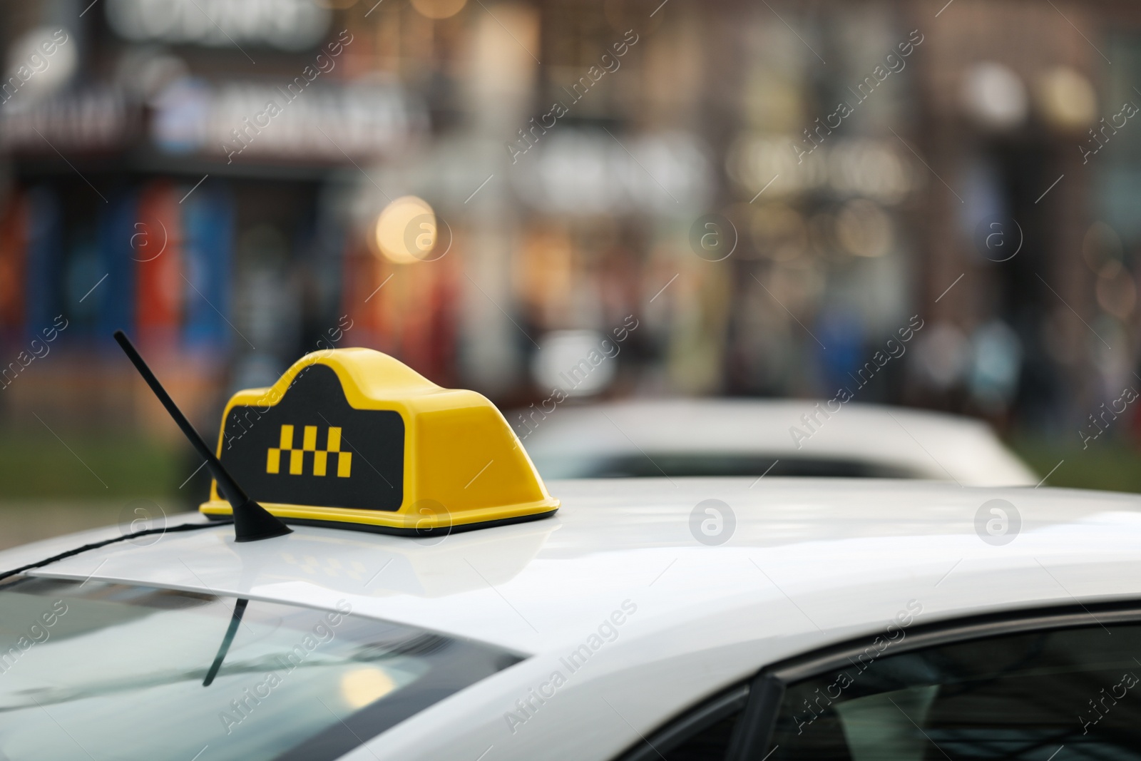 Photo of Taxi cab with yellow sign on city street, closeup