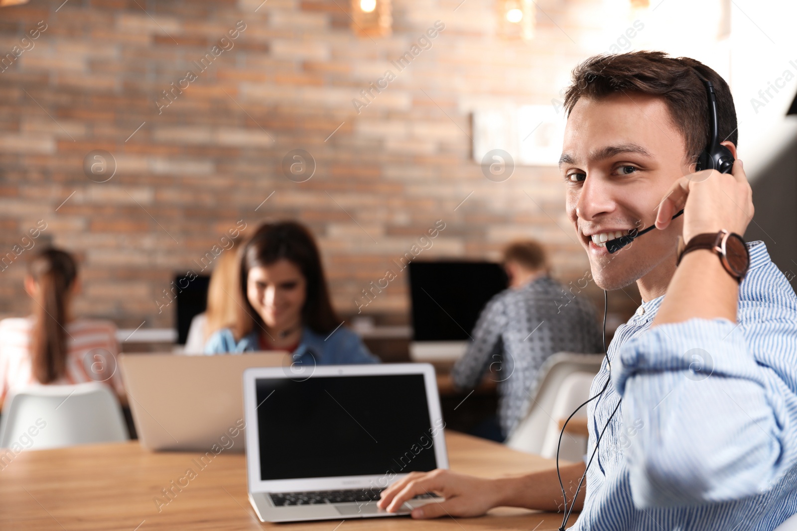 Photo of Technical support operator with headset in modern office