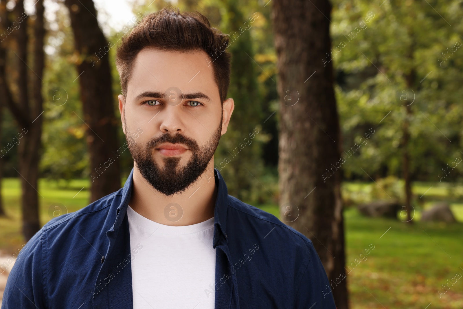 Photo of Portrait of handsome young man in park, space for text