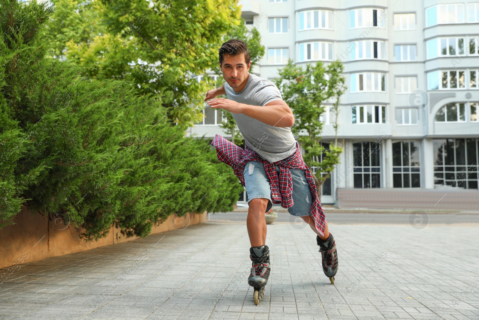 Photo of Handsome young man roller skating outdoors. Recreational activity