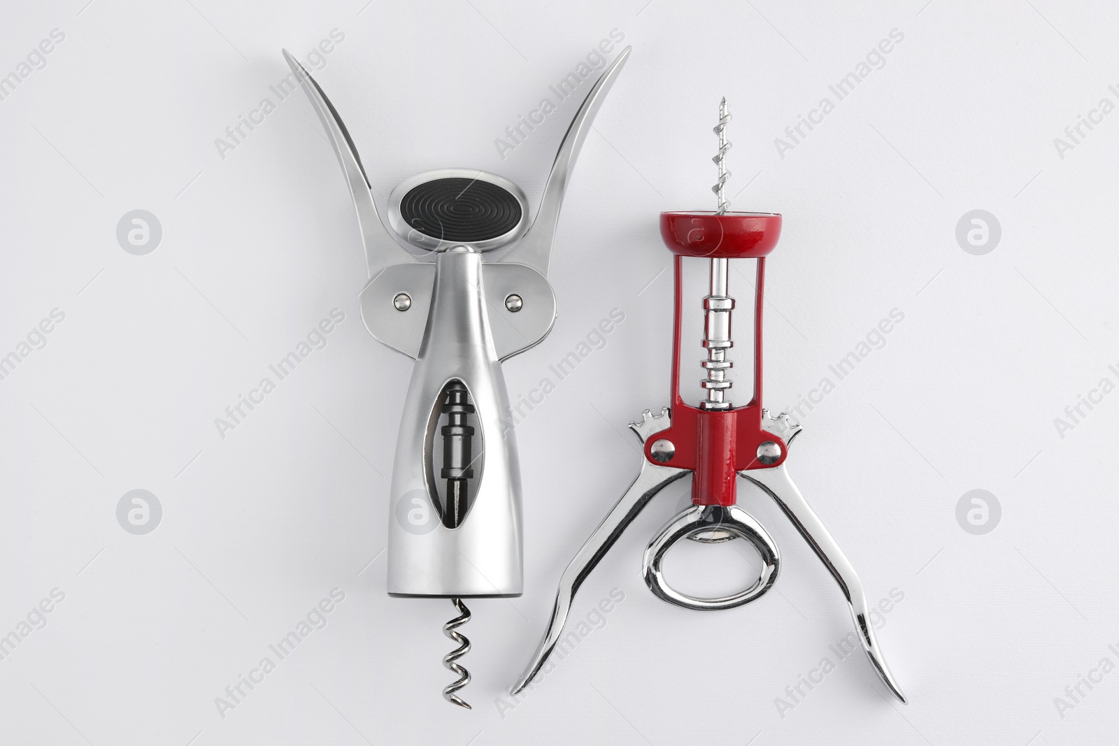 Photo of Different corkscrews on white background, flat lay