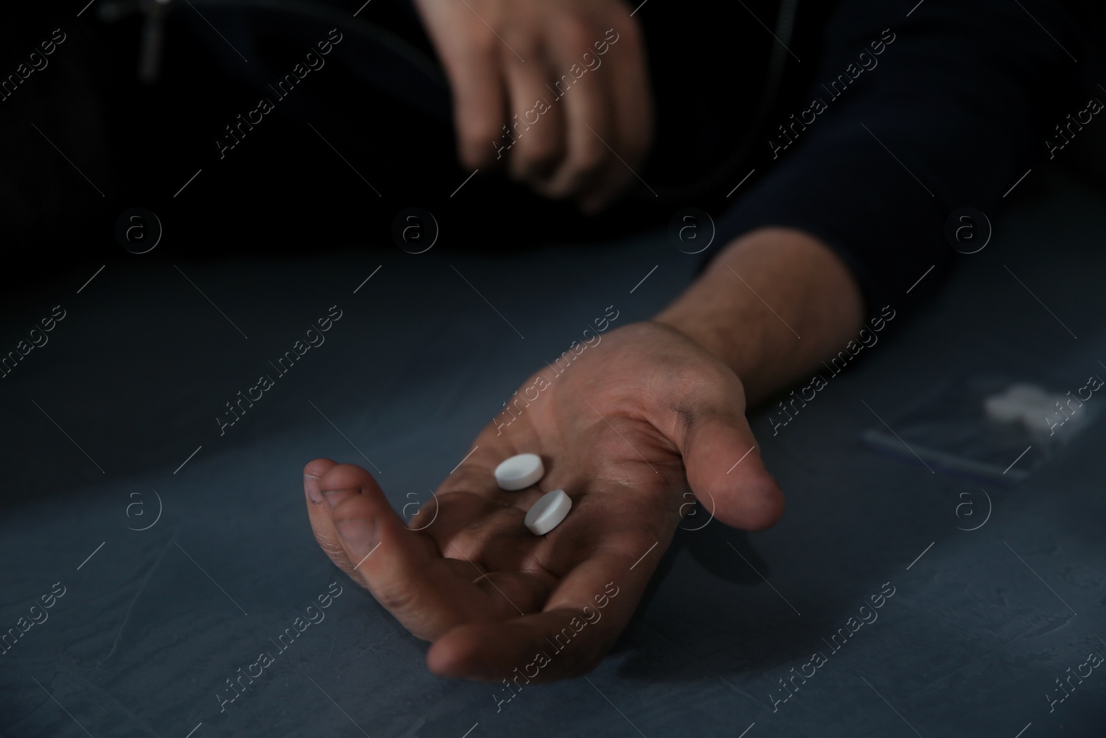 Photo of Young addicted man holding drugs, closeup view