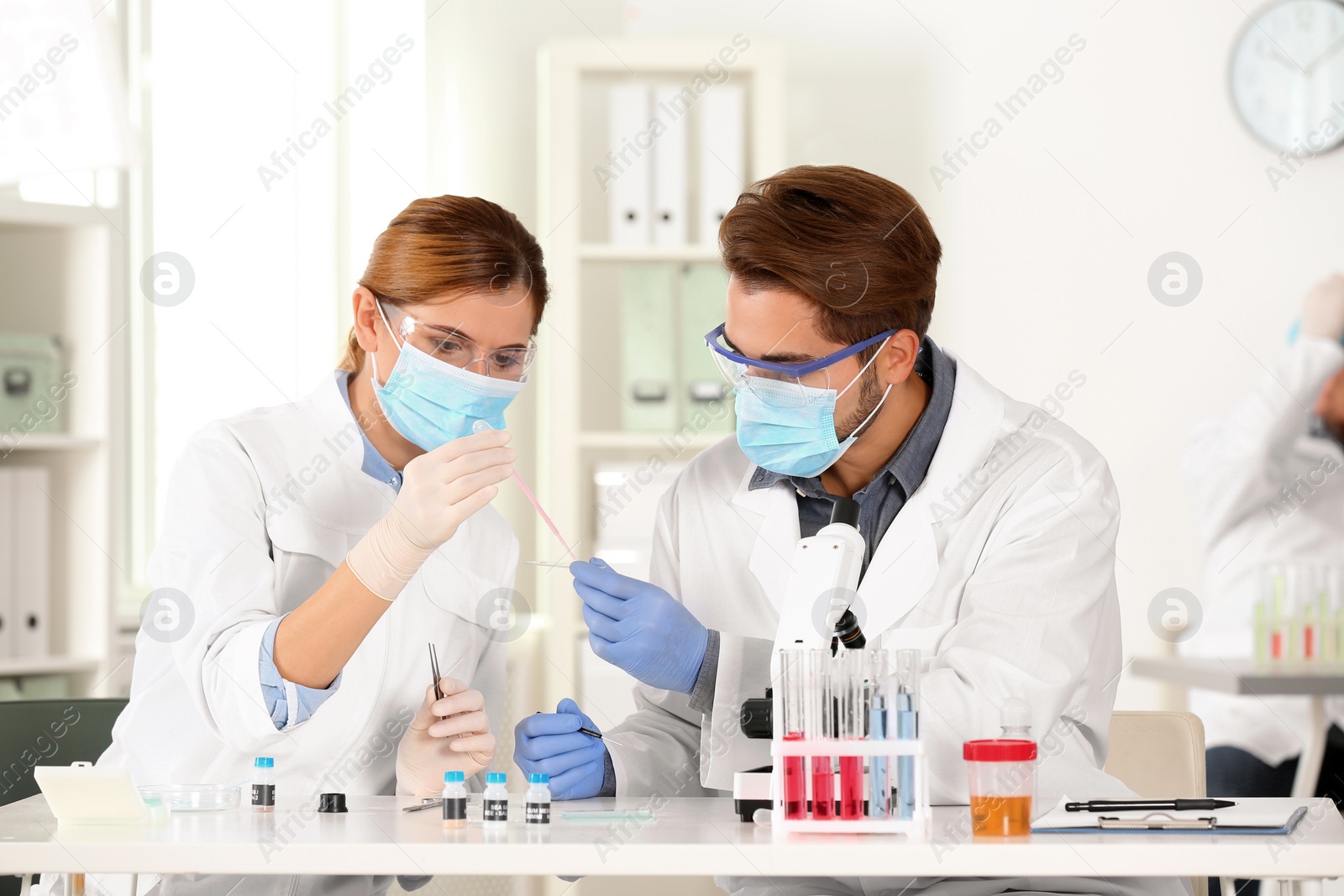 Photo of Scientists working at table in laboratory. Research and analysis