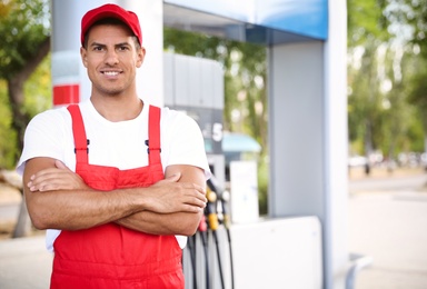 Worker in uniform at modern gas station