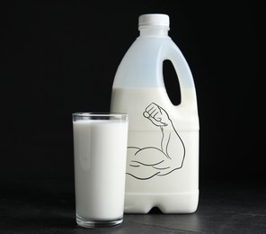 Image of Gallon bottle and glass of milk on black table. Container with illustration of bodybuilder's arm