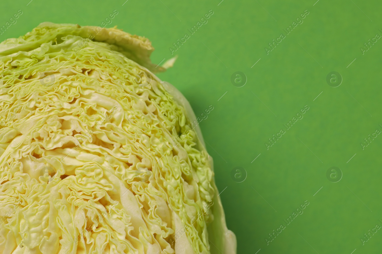 Photo of Cut fresh Chinese cabbage on light green background, top view. Space for text