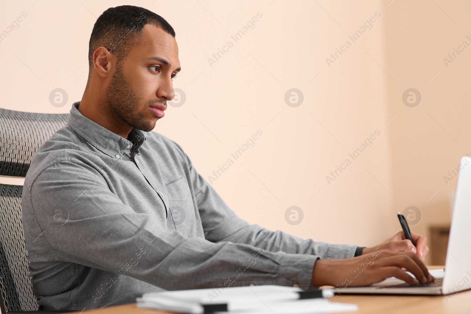 Photo of Businessman working with documents at wooden table in office