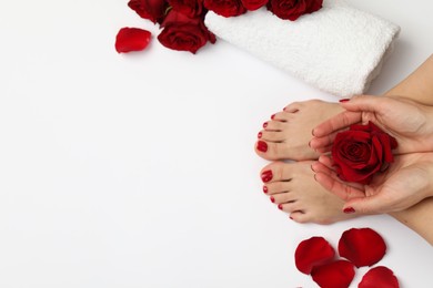 Photo of Woman with stylish red toenails after pedicure procedure and rose flowers on white background, top view. Space for text
