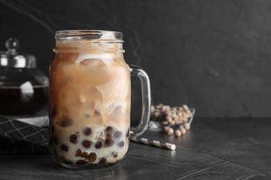 Tasty brown milk bubble tea on grey table, closeup. Space for text