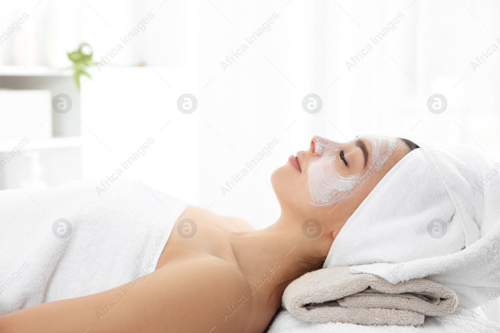 Photo of Pretty woman with mask on her face in spa salon