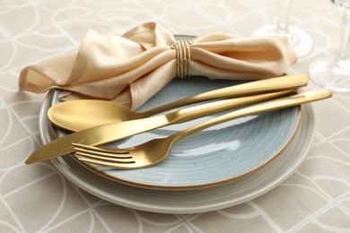 Photo of Stylish setting with cutlery, plates and napkin on table