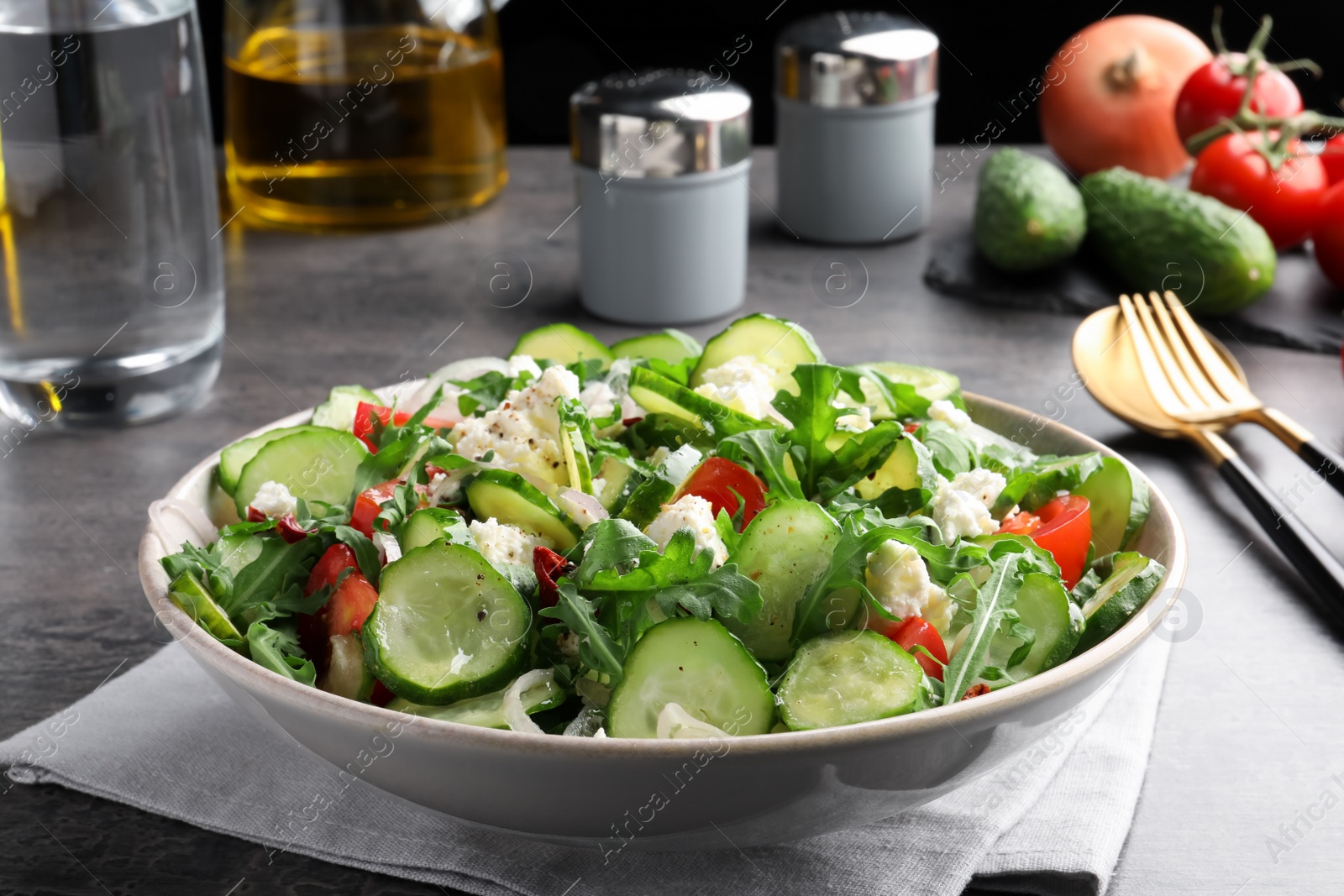 Photo of Plate of delicious cucumber salad served on grey table