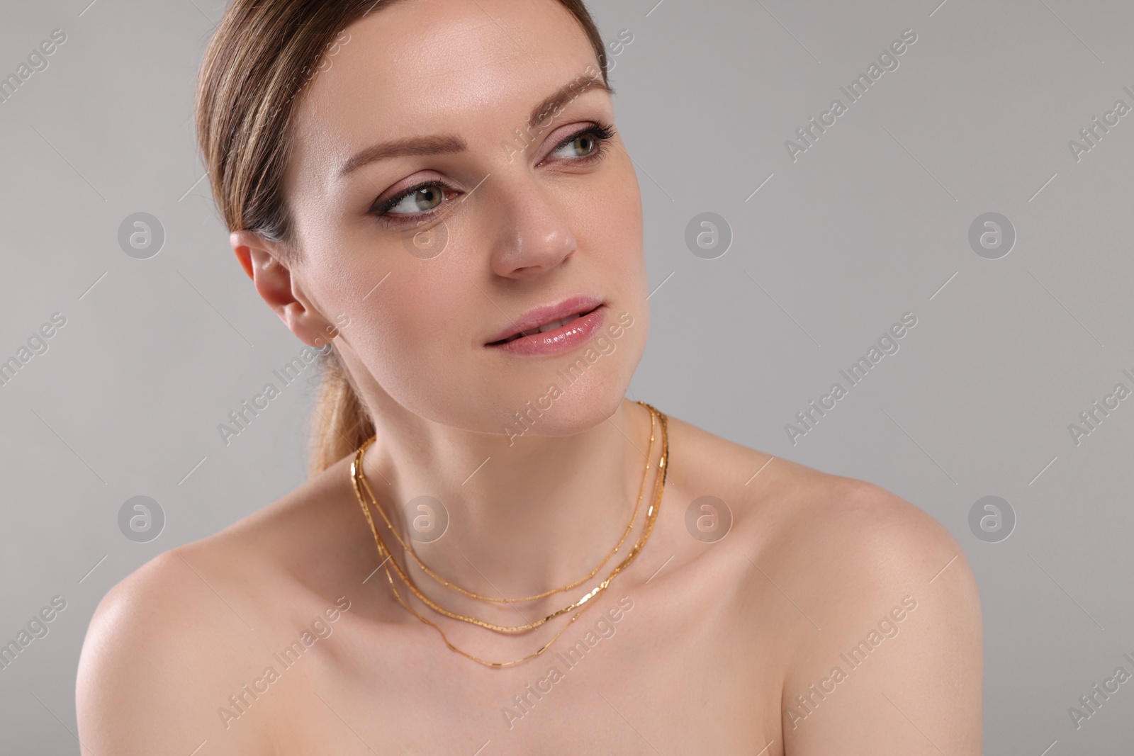 Photo of Beautiful woman with elegant necklace on light grey background