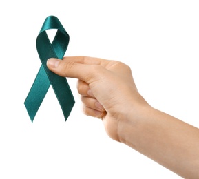 Woman holding teal awareness ribbon against white background, closeup