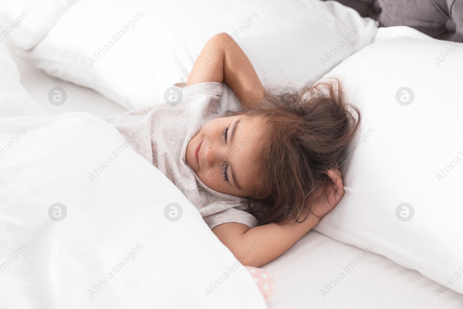 Photo of Cute little girl sleeping in cozy bed