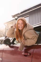 Photo of Happy young woman looking out of car window. Winter vacation