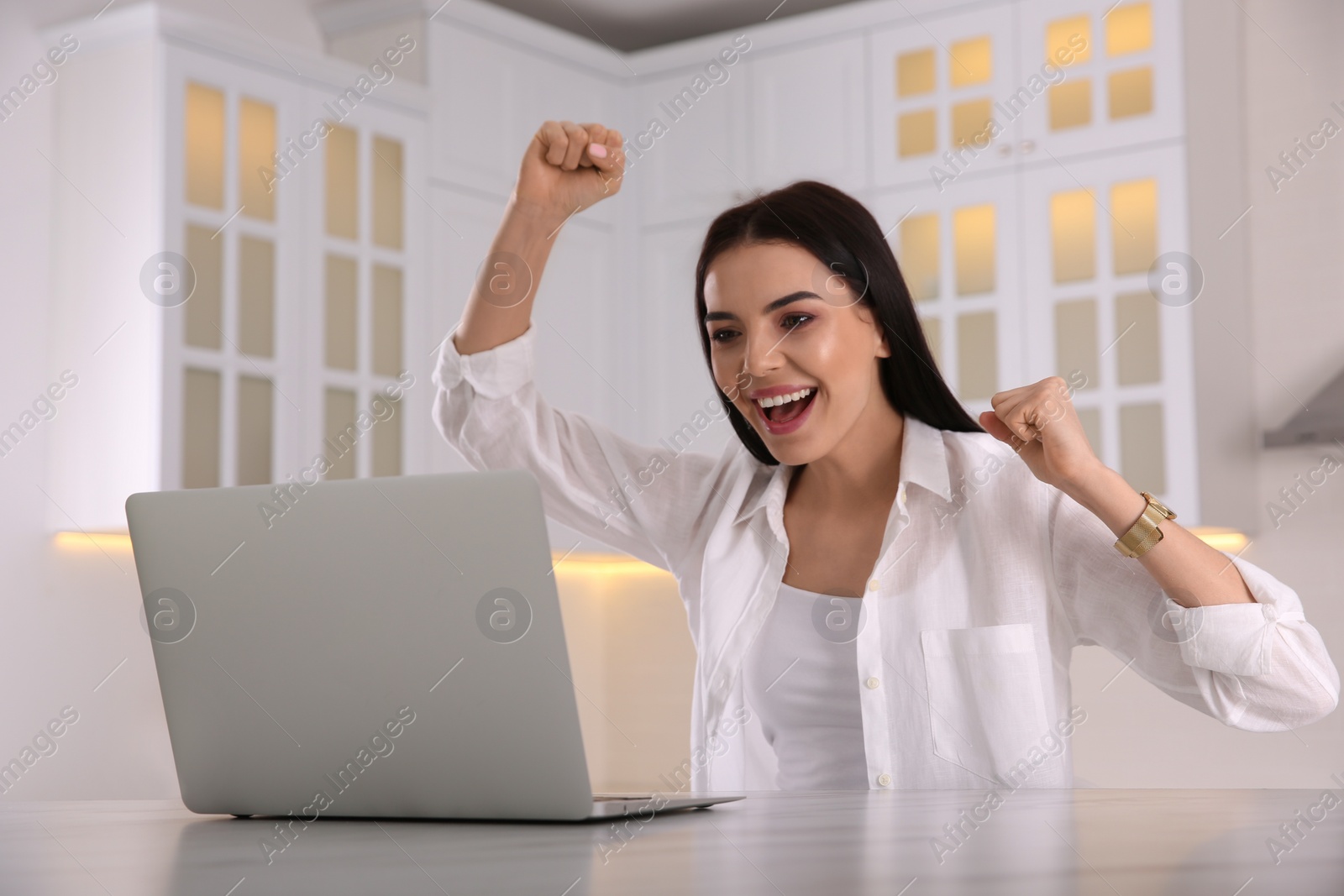 Photo of Emotional woman participating in online auction using laptop at home