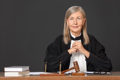 Portrait of judge in court dress at table indoors. Space for text