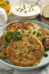Photo of Delicious zucchini fritters served on table, closeup