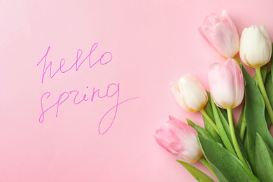 Photo of Words HELLO SPRING and fresh tulip flowers on pink background, flat lay