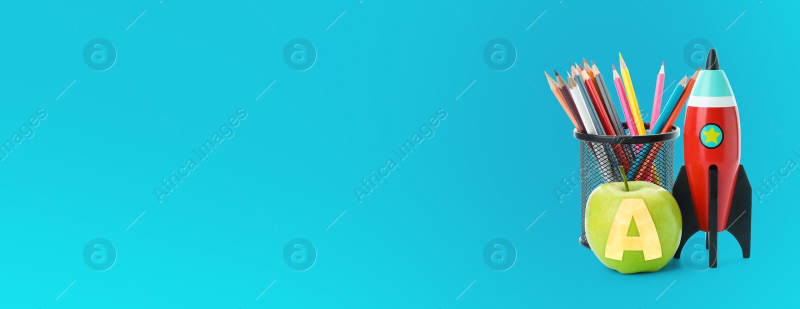 Image of Apple with carved letter A as school grade. Bright toy rocket and pencils on light blue background. Banner design with space for text