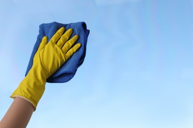 Photo of Woman cleaning window glass with rag, closeup. Space for text