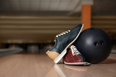 Photo of Shoes and ball on bowling lane in club. Space for text